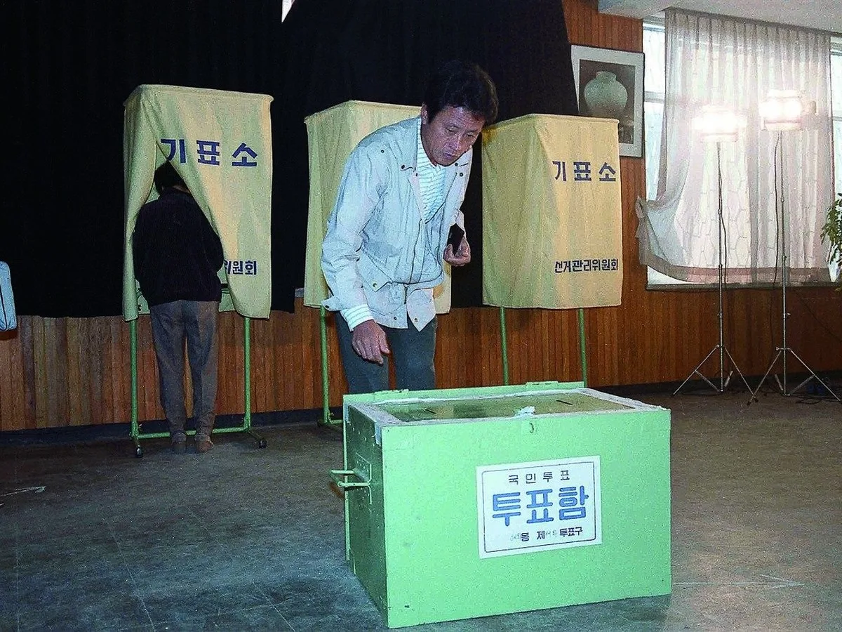 1987년 10월 27일 대통령 직선제 개헌 국민투표소에서 투표함 옆에 서 있는 시민
